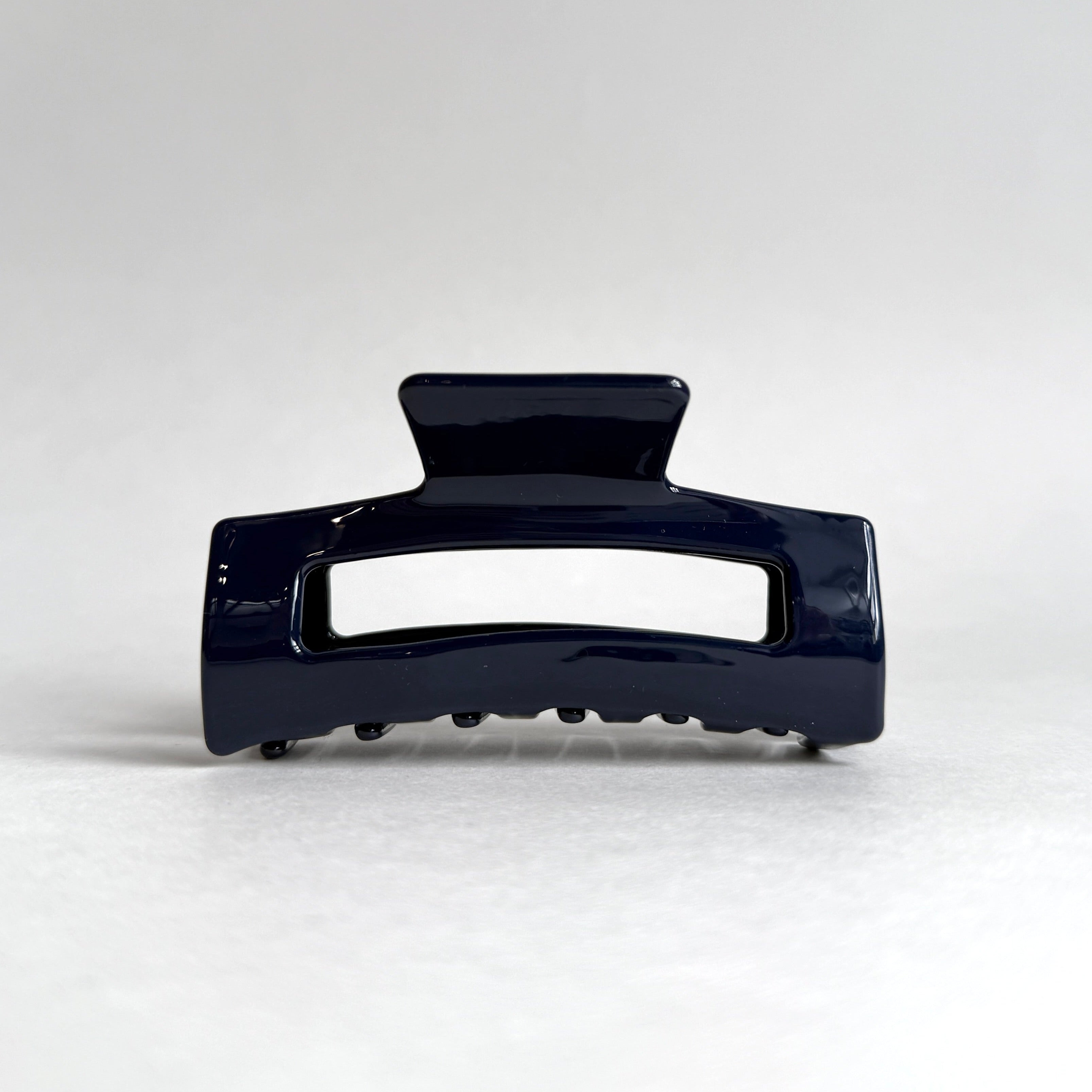 Navy blue hair clip on a white background