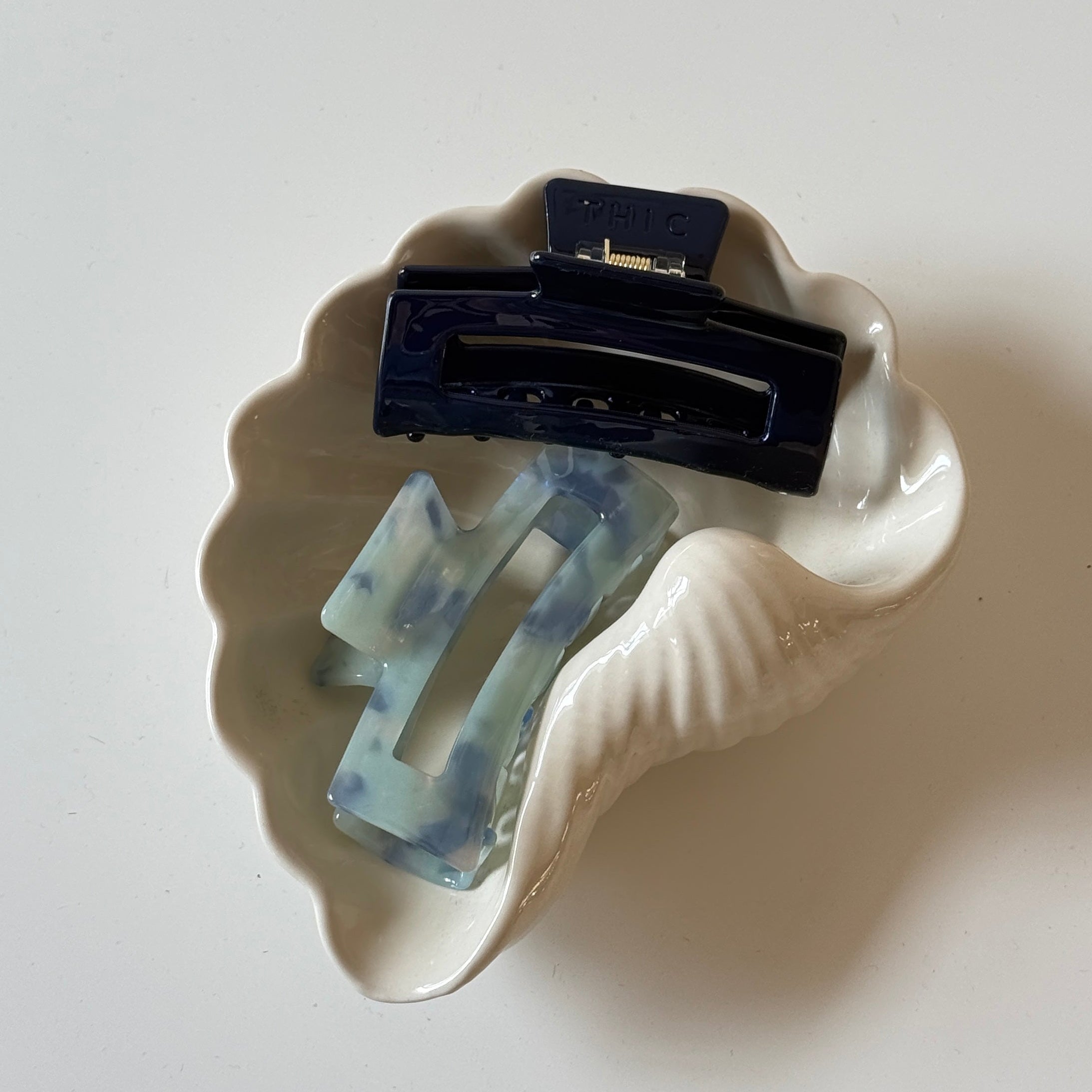 Hair clip with blue and clear design on a white base